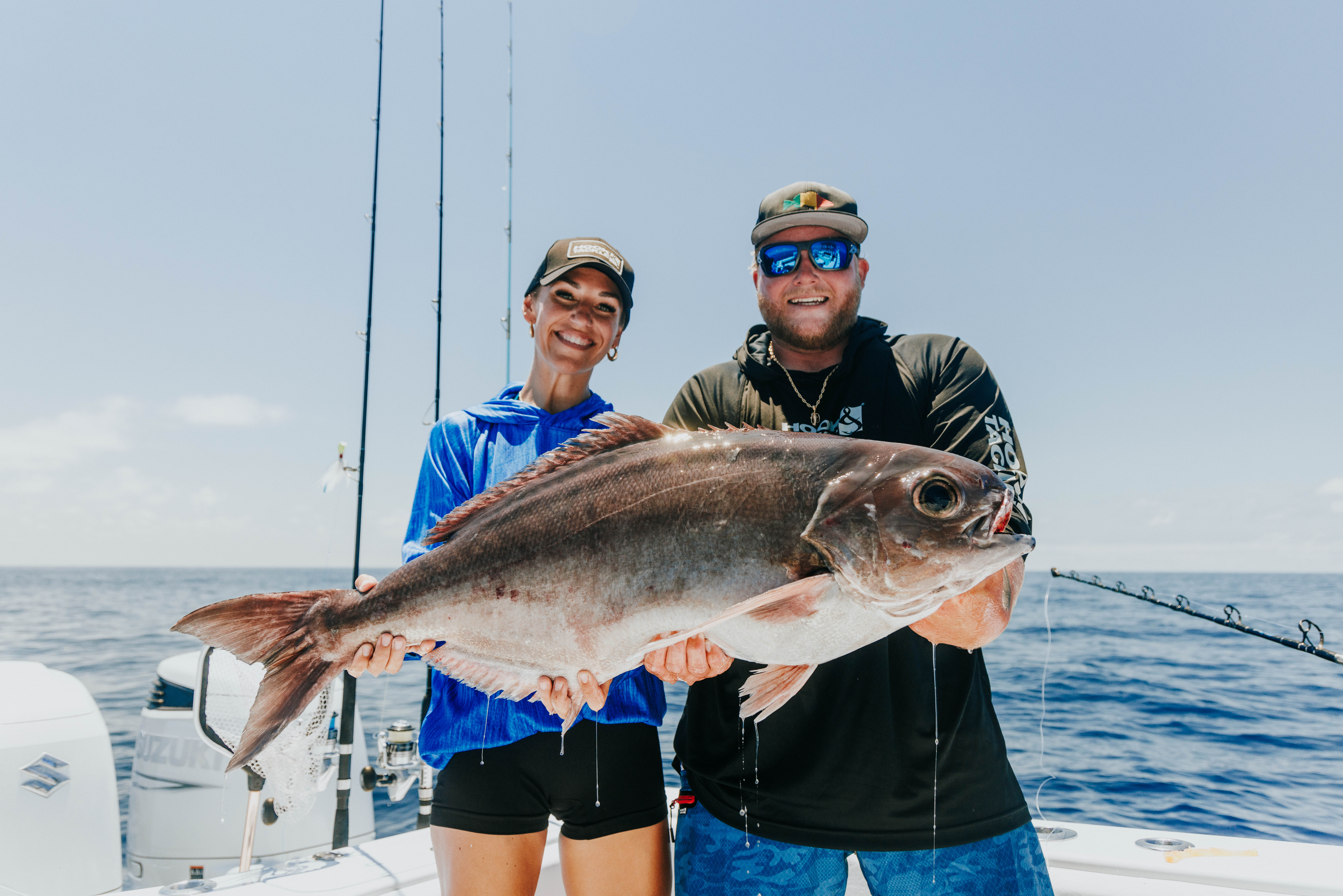 Couple holding large offshore fish catch — outdoor lifestyle photography